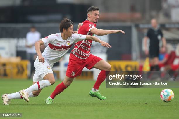 Hiroki Ito of VfB Stuttgart challenges Mergim Berisha of FC Augsburg during the Bundesliga match between VfB Stuttgart and FC Augsburg at...