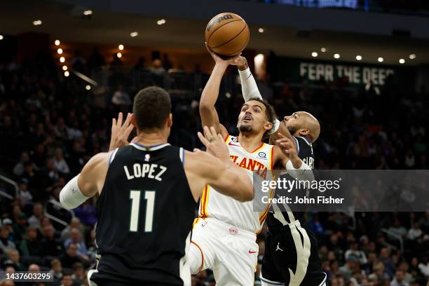 Trae Young of the Atlanta Hawks scores on a running shot between Jevon Carter and Brook Lopez of the Milwaukee Bucks during the second half of the...