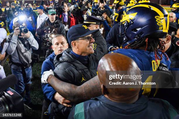 Head Football Coach Jim Harbaugh and Eyabi Okie of the Michigan Wolverines celebrate after winning a college football game against the Michigan State...