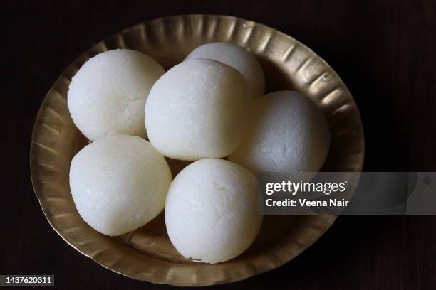 close-up of rasgulla/rasogolla in a copper plate on a wooden table - west bengal stock pictures, royalty-free photos & images