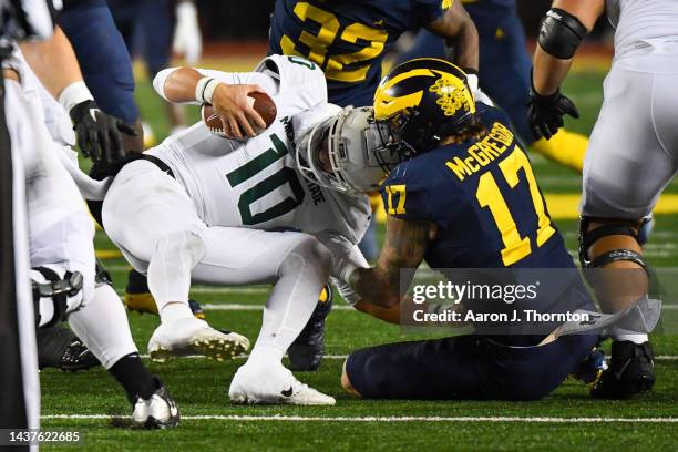 Payton Thorne of the Michigan State Spartans is sacked by Braiden McGregor of the Michigan Wolverines during the second half of a college football...