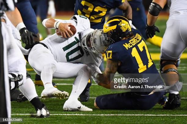 Payton Thorne of the Michigan State Spartans is sacked by Braiden McGregor of the Michigan Wolverines during the second half of a college football...