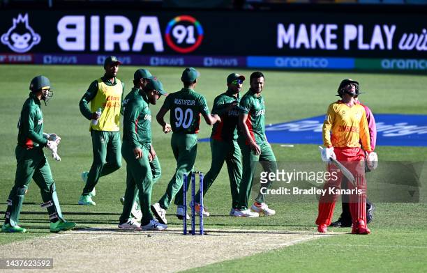 Shakib Al Hasan of Bangladesh celebrates running out Sean Williams of Zimbabwe who looks dejected as he walks from the field during the ICC Men's T20...