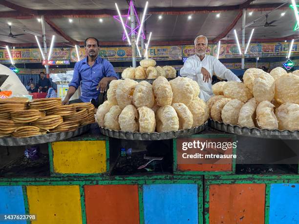 close-up image of street food market stall with vendors selling snacks from trays, focus on foreground - parantha stock pictures, royalty-free photos & images