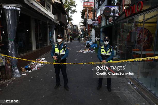 Police officers stand at the scene of a deadly stampede during a Halloween festival on October 30, 2022 in Seoul, South Korea. 151 people have been...