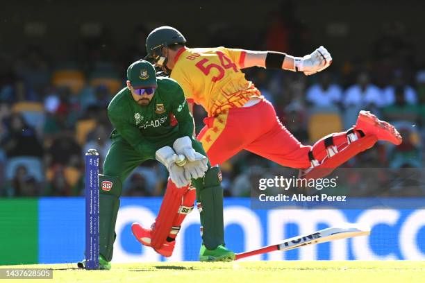 Nurul Hasan of Bangladesh attempts to run out Ryan Burl of Zimbabwe during the ICC Men's T20 World Cup match between Bangladesh and Zimbabwe at The...