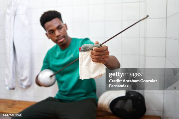 a fencer cleaning his sword before practice - mask confrontation stock pictures, royalty-free photos & images