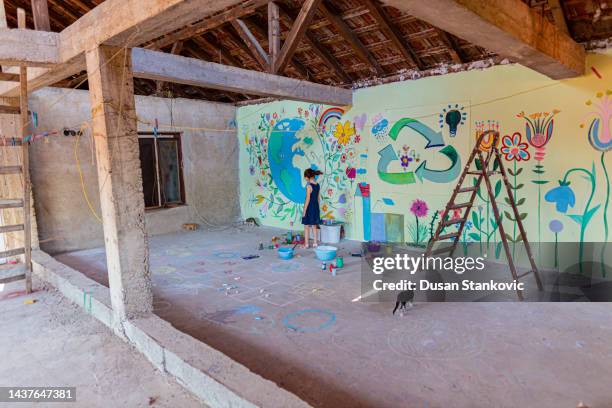young female artist painting the mural - creative space stock pictures, royalty-free photos & images