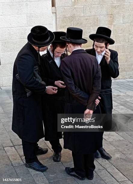 estudantes rabínicos ortodoxos olhando suas mensagens de telefone celular. - haredi judaism - fotografias e filmes do acervo