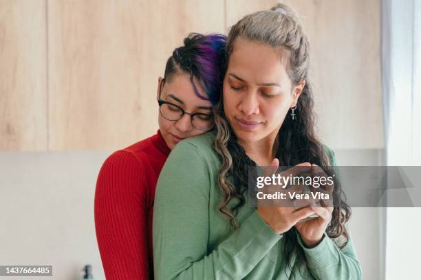 gay latin american women hugging in love at home. - photos of lesbians kissing stock pictures, royalty-free photos & images