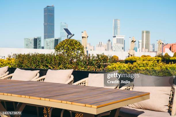 tables and chairs in the city park - balcony restaurant stock pictures, royalty-free photos & images