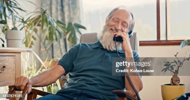 retirement, senior and man on landline phone call enjoying casual communication in australia home. pension, elderly and mature male on armchair in happy and friendly conversation on telephone. - telefone fixo imagens e fotografias de stock