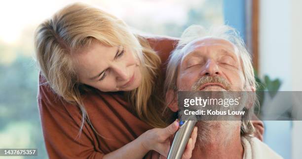 love, hair and mature woman shaving man face during lockdown, grooming, styling and hygiene in their home. family, beauty and senior couple bonding while trim beard with electric shaver at home - electric razor stock pictures, royalty-free photos & images