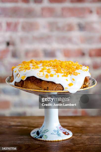 lemon cake drizzled in icing, decorated with rind - zitronentorte stock-fotos und bilder