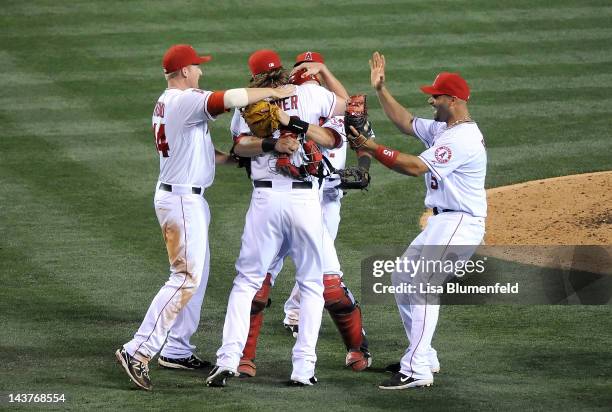 Jered Weaver of the Los Angeles Angels of Anaheim celebrates with teammates Chris Iannetta, Mark Trumbo, Erick Aybar and Albert Pujols after throwing...