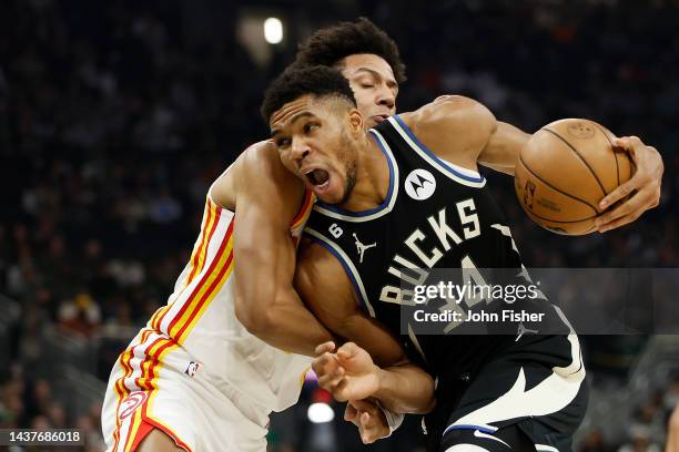 Giannis Antetokounmpo of the Milwaukee Bucks drives to the basket on Jalen Johnson of the Atlanta Hawks during the first half of the game at Fiserv...