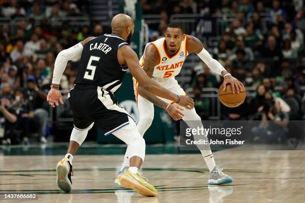 Dejounte Murray of the Atlanta Hawks looks to dribble while being guarded by Jevon Carter of the Milwaukee Bucks during the second half of the game...