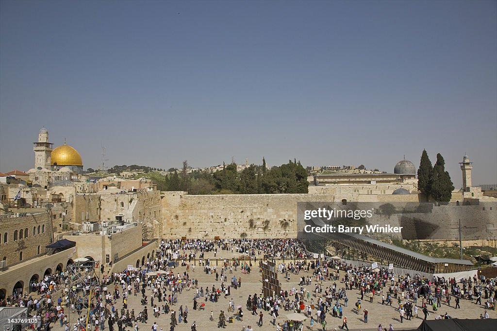 Vista of crowded plaza below Jerusalem stone wall.