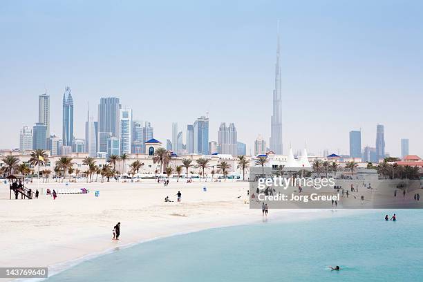 dubai skyline and jumeirah open beach - dubai city stockfoto's en -beelden