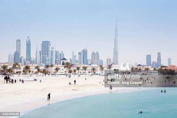 dubai skyline and jumeirah open beach - dubai stock pictures, royalty-free photos & images