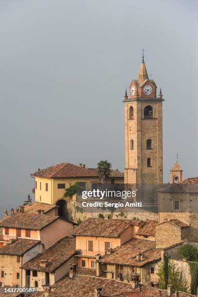 chiesa di santa elisabetta bell tower and pigeons flying in monforte d’alba, piedmont, italy - flyingconi stock pictures, royalty-free photos & images