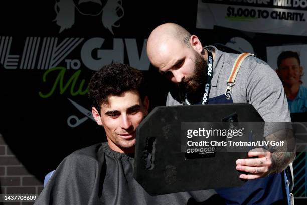 Team Captain Joaquín Niemann of Torque GC looks at his mullet haircut at the LIV to Give Mullets charity booth during the team championship...