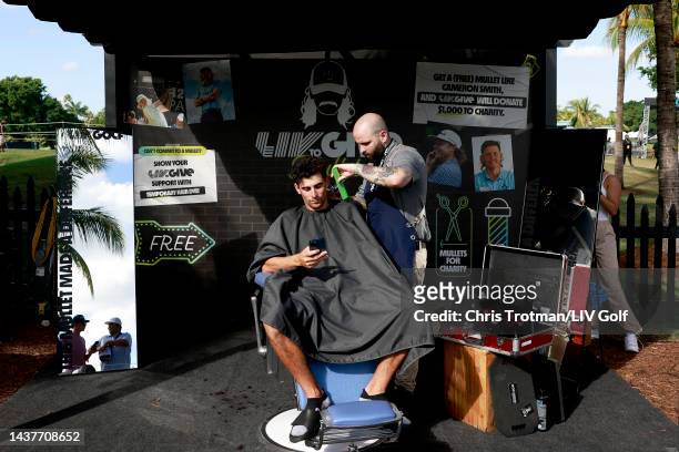 Team Captain Joaquín Niemann of Torque GC gets a mullet haircut at the LIV to Give Mullets charity booth during the team championship stroke-play...