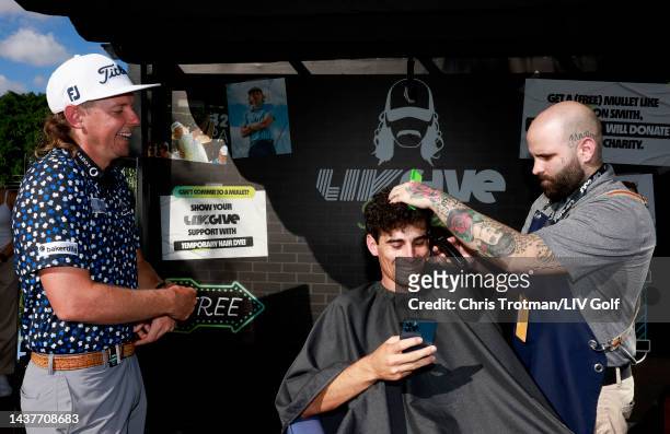Team Captain Joaquín Niemann of Torque GC gets a mullet haircut at the LIV to Give Mullets charity booth as team Captain Cameron Smith of Punch GC...