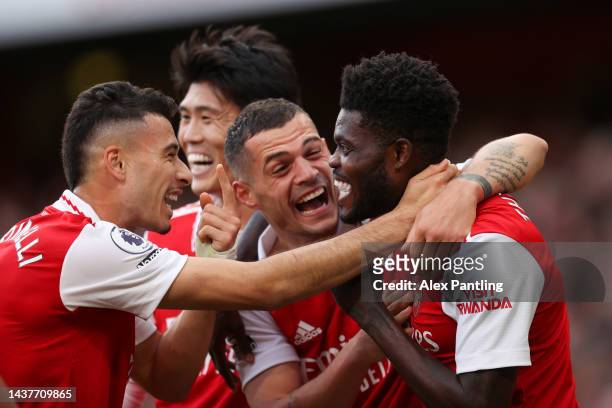 Thomas Partey of Arsenal celebrates with teammates Gabriel Martinelli and Granit Xhaka after scoring their team's fourth goal during the Premier...