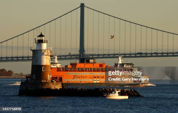 The Staten Island Ferry passes between the Robbins Reef Lighthouse and the Verrazzano-Narrows Bridge in New York City on October 29 in Bayonne, New...