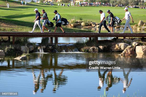 Jordan Smith of England, Gavin Green of Malaysia and Sebastien Heisele of Germany cross the bridge to the fairway on the 17th hole during Day Four of...