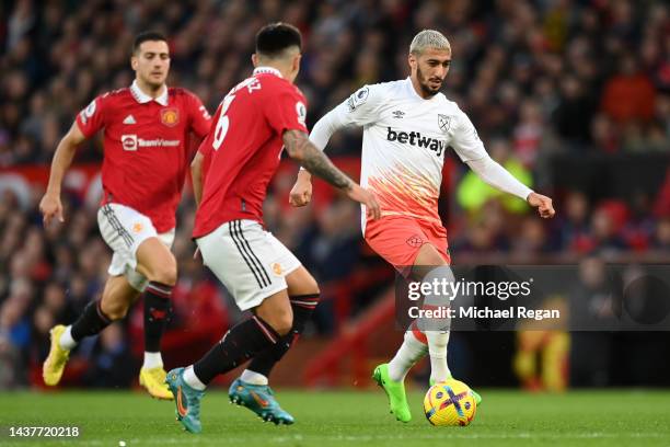 Said Benrahma of West Ham United is put under pressure by Lisandro Marti­nez of Manchester United during the Premier League match between Manchester...