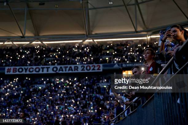 Fans show their support as a sign reads "#Boycott Qatar 2022" prior to the Bundesliga match between FC Schalke 04 and Sport-Club Freiburg at...