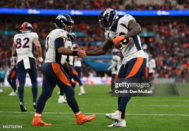 Latavius Murray of the Denver Broncos celebrates with teammate Russell Wilson after scoring a touchdown during the fourth quarter in the NFL match...