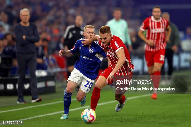 Philipp Lienhart of SC Freiburg battles for possession with Florent Mollet of FC Schalke 04 during the Bundesliga match between FC Schalke 04 and...