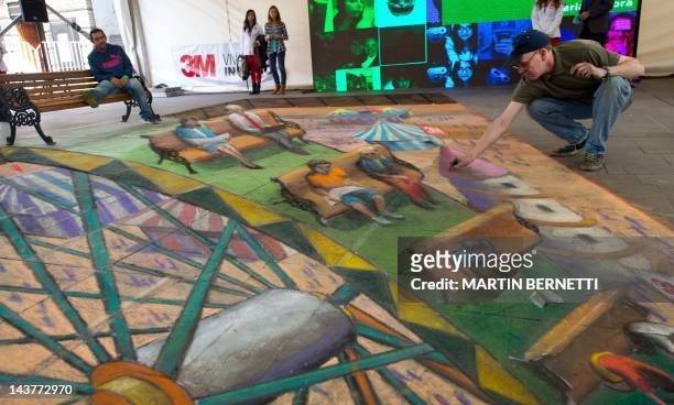 British artist Julian Beever, specialized in pavement drawings, wall murals and realistic paintings, works on May 3, 2012 in Santiago. Beever...