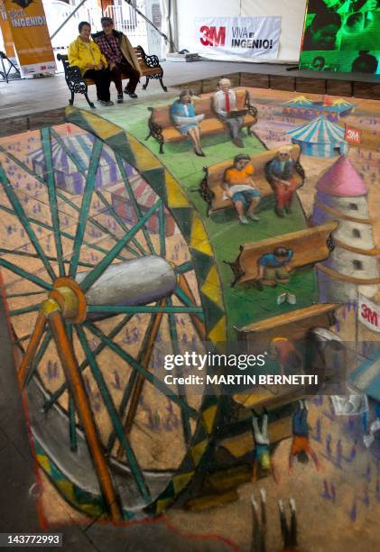 Chilean people poses on the work of British artist Julian Beever, specialized in pavement drawings, wall murals and realistic paintings, on May 3,...