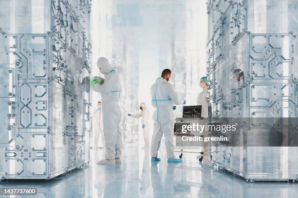 futuristischer serverraum mit quantencomputern und wissenschaftlergruppe - quantencomputer stock-fotos und bilder