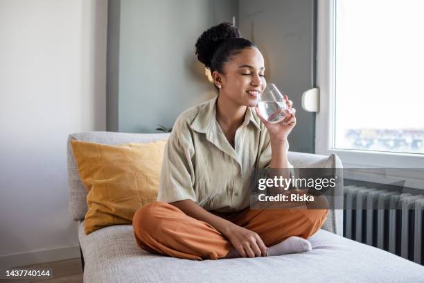 maintaining healthy habits - black woman drinking water stock pictures, royalty-free photos & images