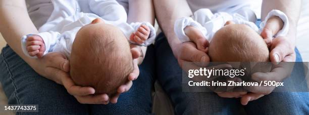 newborn twins on the bed,in the arms of their parents life style,emotions of kids banner,barcelona,spain - multiple birth stock pictures, royalty-free photos & images