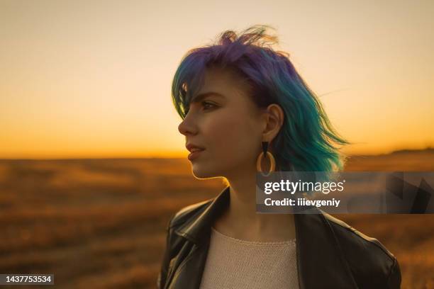 blue hair woman in jacket in against backdrop of sunset. pretty girl enjoying vacation. dyed hair - belarus nature stock pictures, royalty-free photos & images