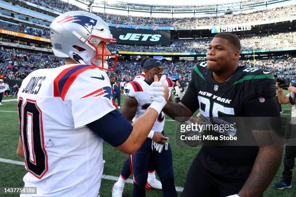 Mac Jones of the New England Patriots and Quinnen Williams of the New York Jets shake hands after a game at MetLife Stadium on October 30, 2022 in...