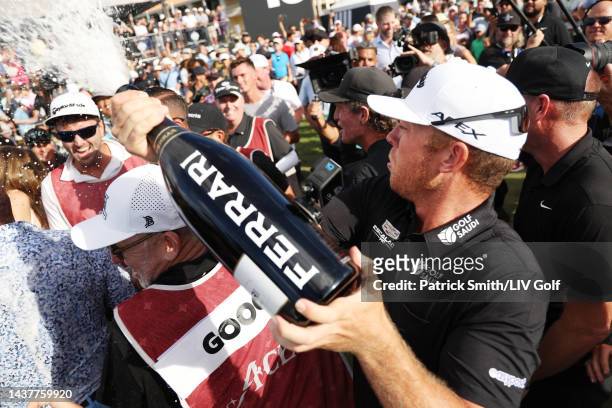 Talor Gooch of 4 Aces GC sprays champagne in celebration of the 4 Aces GC team win on the 18th green during the team championship stroke-play round...