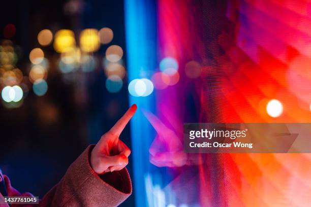 close-up of  female hand touching illuminated digital screen - ai human hand stock pictures, royalty-free photos & images