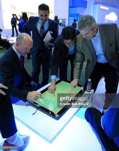Computer show attendees examine a new adaptive all-in-one system with large touch-enabled screens during CES, January 8, 2013 in Las Vegas, Nevada.