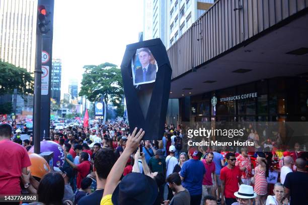 Supporter of candidate Luiz Inácio Lula da Silva of Workers' Party holds a sign shaped like a coffin with the image of Jair Bolsonaro on presidential...