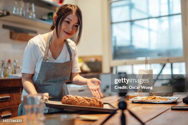 female blogger filming video with smartphone while baking bread - live broadcast stock pictures, royalty-free photos & images