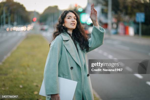 une jeune femme traverse la rue à l’heure de pointe - trench stock photos et images de collection