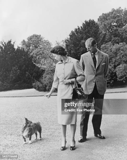 Queen Elizabeth II and Prince Philip with their corgi Sugar, outside the George IV gateway at Windsor Castle, 6th June 1959.