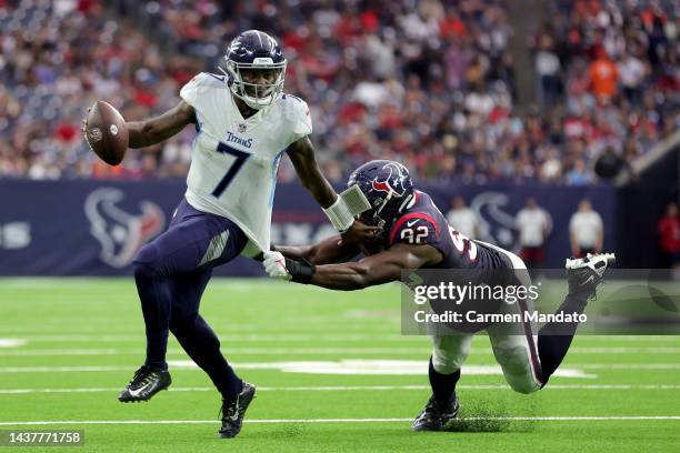 Malik Willis of the Tennessee Titans runs with the ball as Rasheem Green of the Houston Texans defends during the fourth quarter at NRG Stadium on...